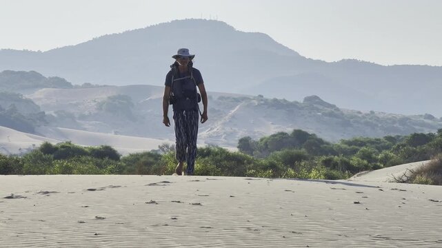 A summer walk through the dunes of a sandy desert. A man in the desert. The Lycian Way tourist route. T&uuml;rkiye.
