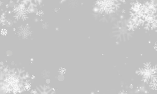 White snowflakes float delicately over a dark background. The snowflakes vary in size, opacity, and detail creating a soft, dreamy effect. This scene is ideal for winter holiday themes or.