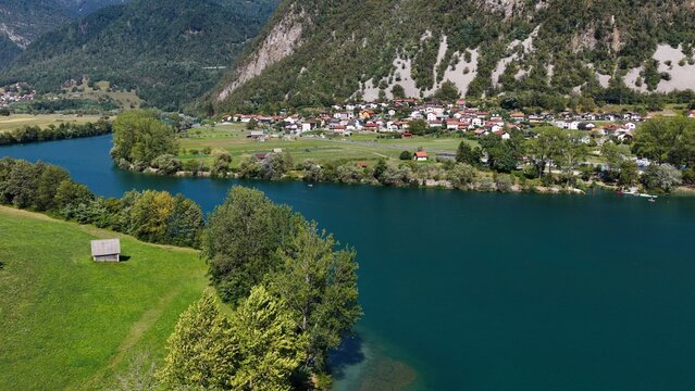 Aerial view of Most na Soci with the Soca River, Santa Lucia, Slovenia. Canoes, SUPs, and swimmers in the water.