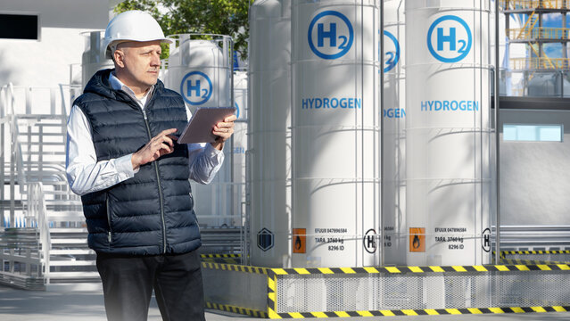 Hydrogen production plant inspection engineer monitors hydrogen storage tanks using tablet at industrial facility, ensuring safety and operations control