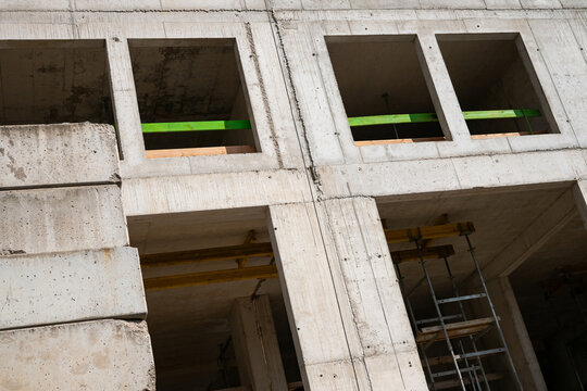 Concrete residential building under construction. Modern apartment development site.