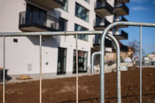 Blurred construction site through wire fence - abstract view of development in progress.