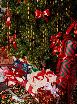 Gifts Arranged Under a Christmas Tree With Colorful Decorations