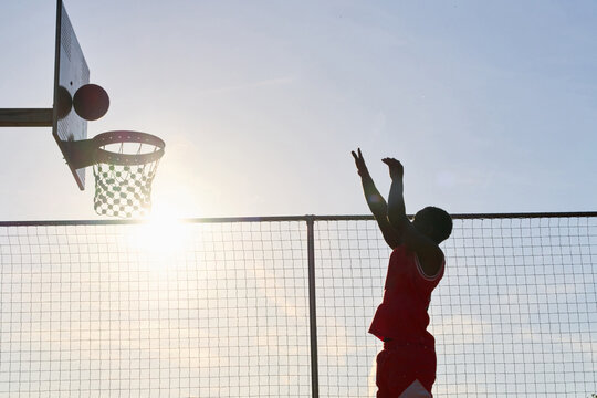 Basketball Player Makes a Shot During Sunset at Outdoor Court