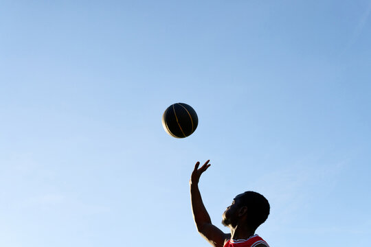 Player Shoots a Basketball in the Sky During a Sunny Day
