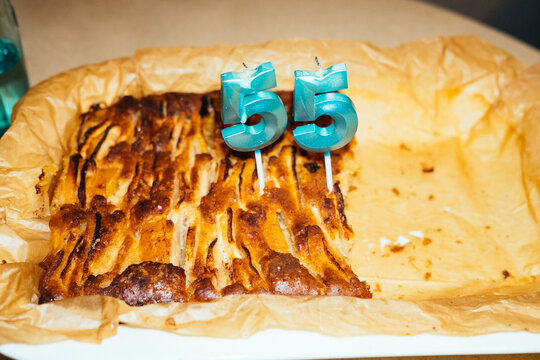 Celebration with a cake featuring candles for age fifty-five