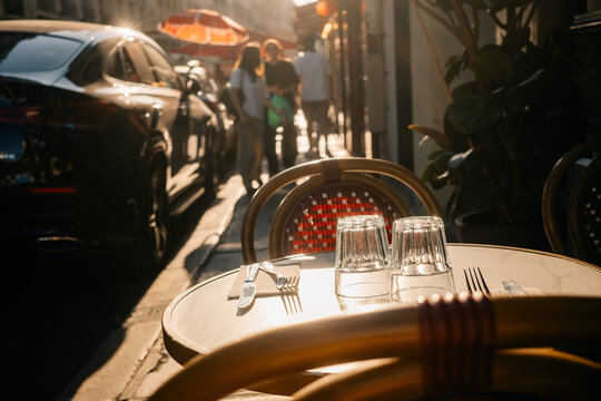 People Walk by Tables at a Cafe During Late Afternoon Light