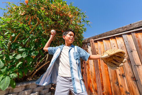 boy playing catch with baseball throwing wearing mitt