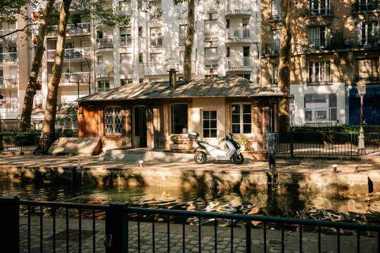 Urban Scene With a Scooter by a Canal in a City Setting