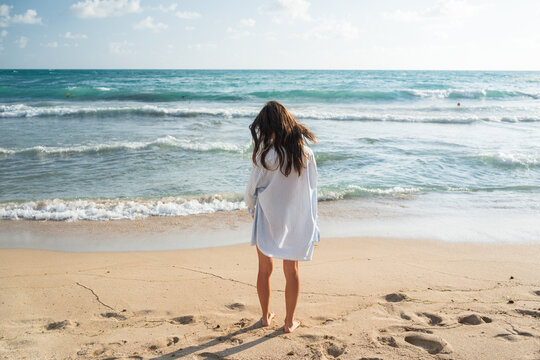 Woman Stands by the Sea in Daylight Near Sandy Beach