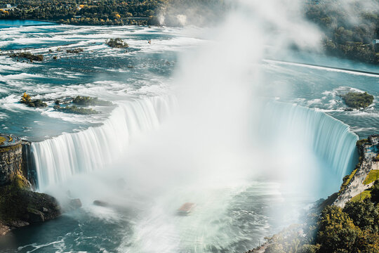 Niagara Falls waterfall cascading over rocky cliff edge with powerful flowing water motion