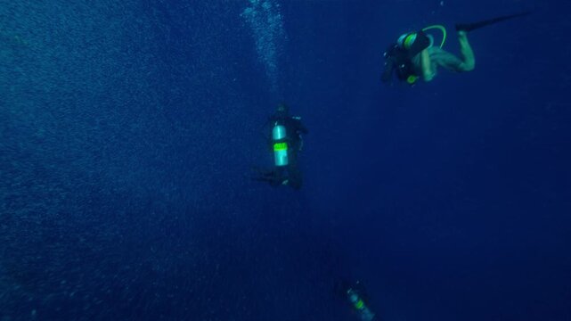 Water surface POV shot of boat and SCUBA Divers descending