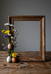 Obraz premium Easter celebration and spring holiday concept, wooden picture frame with fresh wildflowers and organic eggs on a rustic wooden table for seasonal decor