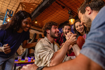 Obraz premium Friends Cheering During Arm Wrestling Match in Pub