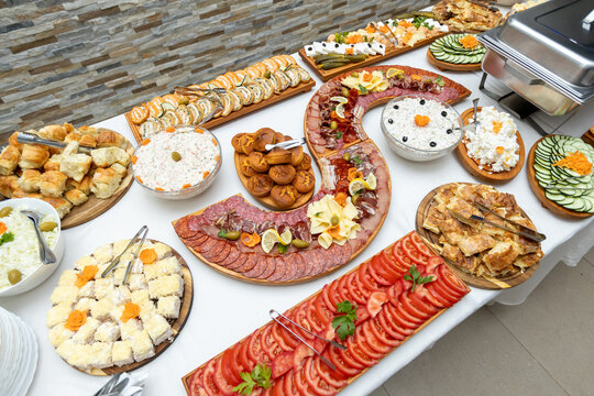 Rich buffet table arrangement with traditional savory dishes salads cold cuts and pastries