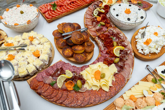 S-shaped cold cut platter with smoked meats cheese cornbread and appetizers at buffet