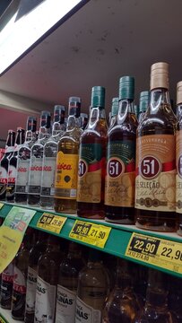 ITABIRA, BRAZIL - AUGUST 26, 2026: Bottles of Brazilian cachaca brands Pirassununga 51, Ypioca, and Salinas displayed on supermarket shelves with price tags in Itabira, Minas Gerais.