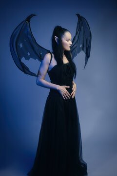 Gothic Mature Woman 40s as Dark Elf with Wings in Blue Mist