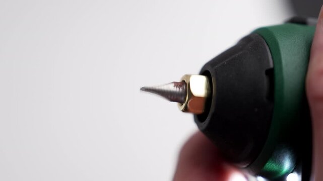 Close up testing a flathead screwdriver bit in electric power tool