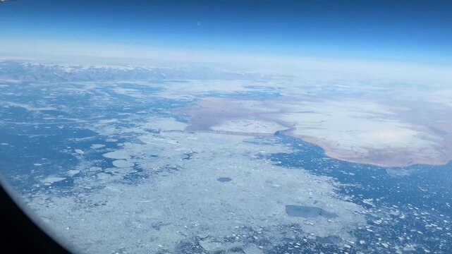 Aerial view of arctic land in northern Greenland. A view out the window from the Helsinki to Seattle arctic polar route towards the Sverdrup Island area at 83 degrees northern latitude.