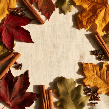 Autumn leaves and spices arranged on a plain background for a seasonal display