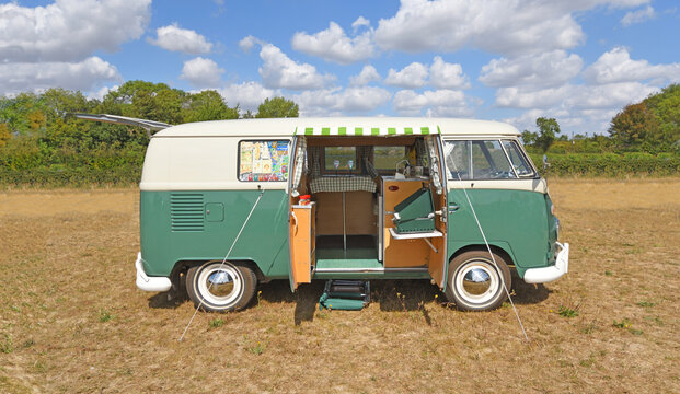  Classic  Volkswagen Type 2 split-screen campervan parked in field with side doors open