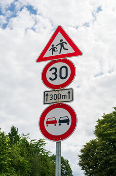German traffic signs warning of children crossing, speed limit and no overtaking