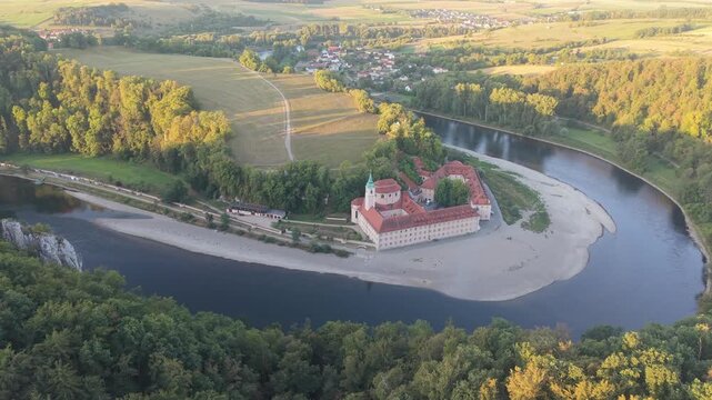 Scenic aerial footage showing the historic Weltenburg Abbey monastery located on a dramatic bend of the Danube River in Bavaria, Germany