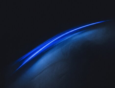 Cinematic blue light trail on dark background, abstract glowing motion lines, futuristic neon energy curve for technology concept