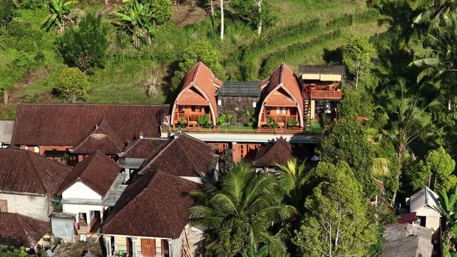 Traditional wooden gabled houses with verandas on lush hillside under warm sunlight, with hous, wooden, gabled, veranda detail, showing roof, terracotta, tile, cluster context