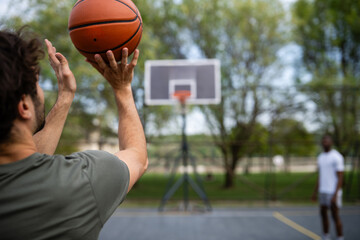 Male player shooting basketball on outdoor court © Zoran Jesic
