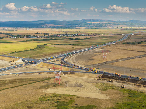 Aerial view of the Autostrada A7 highway junction near Bacau under clear daylight, showing heavy machinery and modern infrastructure development in Romania. Moldova Highway in Romania