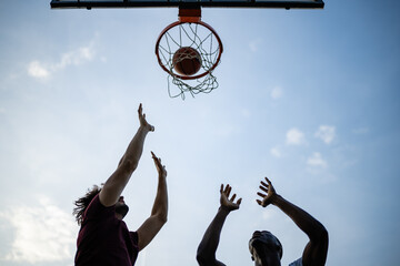 Players competing for basketball shot against sky © Zoran Jesic