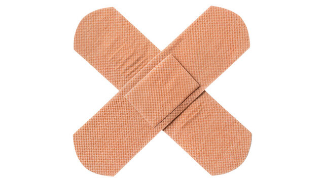 Two beige adhesive bandages crossed over each other, isolated on transparent background
