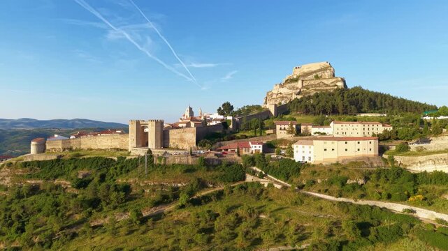 Panoramic view of Morella, a historic medieval walled town in Castellon province, Valencia, Spain, featuring ancient stone walls, towers, and castle ruins atop a rocky hilltop