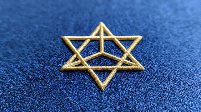 Gold hexagram star embroidered on blue velvet fabric background close up view for holy sacred worship and traditional religious symbol design