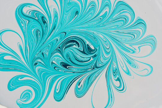Abstract floral ebru paint pattern in turquoise and teal colors isolated on white background.