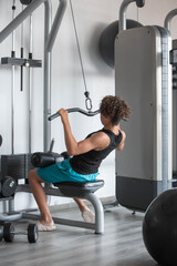 Fototapeta premium Teen boy exercising on a strength training machine in a modern gym, representing youth fitness, healthy lifestyle, physical activity, sports and wellness. Concept of healthy habits