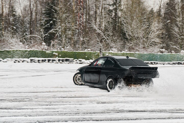 Car drifts across snow with towering pine background and sweeping motion © diczman