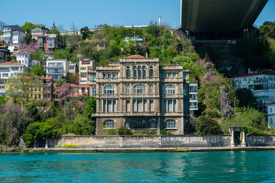 Grandiose villa perched on a lush hillside, overlooking water