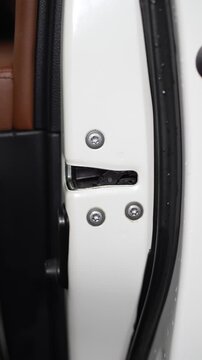 Car white door lock mechanism with installed star Torx bolts.