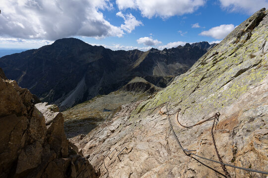 Velka studena dolina, view from Priecne sedlo, High Tatras, Vysoke Tatry, Slovakia. Mountain landscape from the saddle. Via ferrata and chains. Top, peaks and summits in the distance. Unsharp corners.