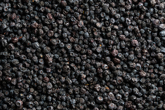 Top view of dense heap of organic dried blueberries, creating natural textured background, closeup. Great for healthy nutrition, superfood ingredients, or packaging design concepts