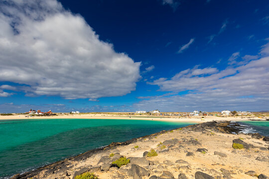 Panoramic view of a volcanic beach and the turquoise Atlantic Ocean under a blue sky on Fuerteventura (Canary Islands) &ndash; a background or wallpaper for your project