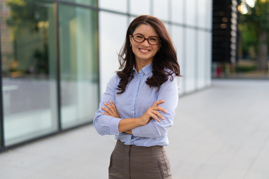 Confident businesswoman smiling with arms crossed outdoors