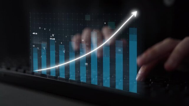 A close-up view of hands on a keyboard with a digital display showing stock market data, featuring a rising graph and currency symbols representing financial analysis. Copula