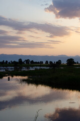 Obraz premium Serene African sunset landscape reflection on calm lake water with distant mountains