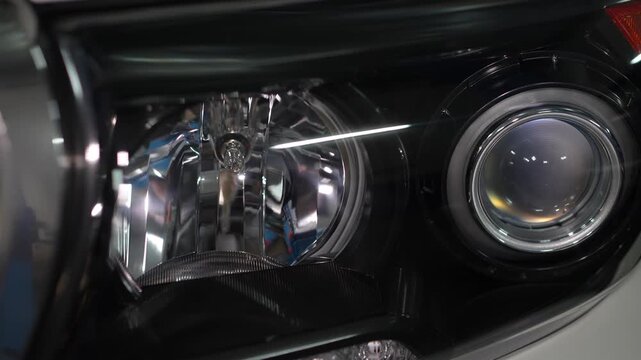 Car headlight assembly featuring a projector lens and reflector housing.