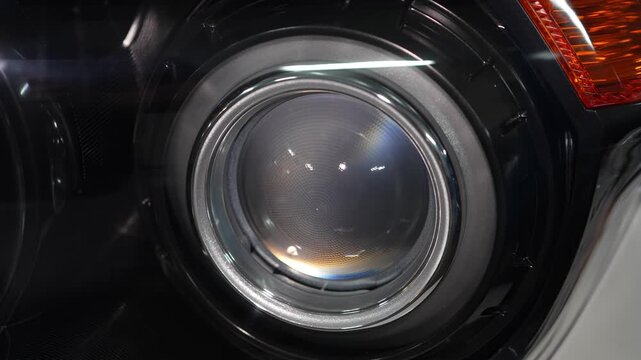 Car headlight projector lens module with a black shroud.