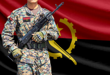 Obraz premium Angola flag with soldier holding assault rifle